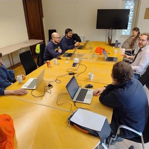 Members of the RSE team sitting round a conference table discussing agile management techniques